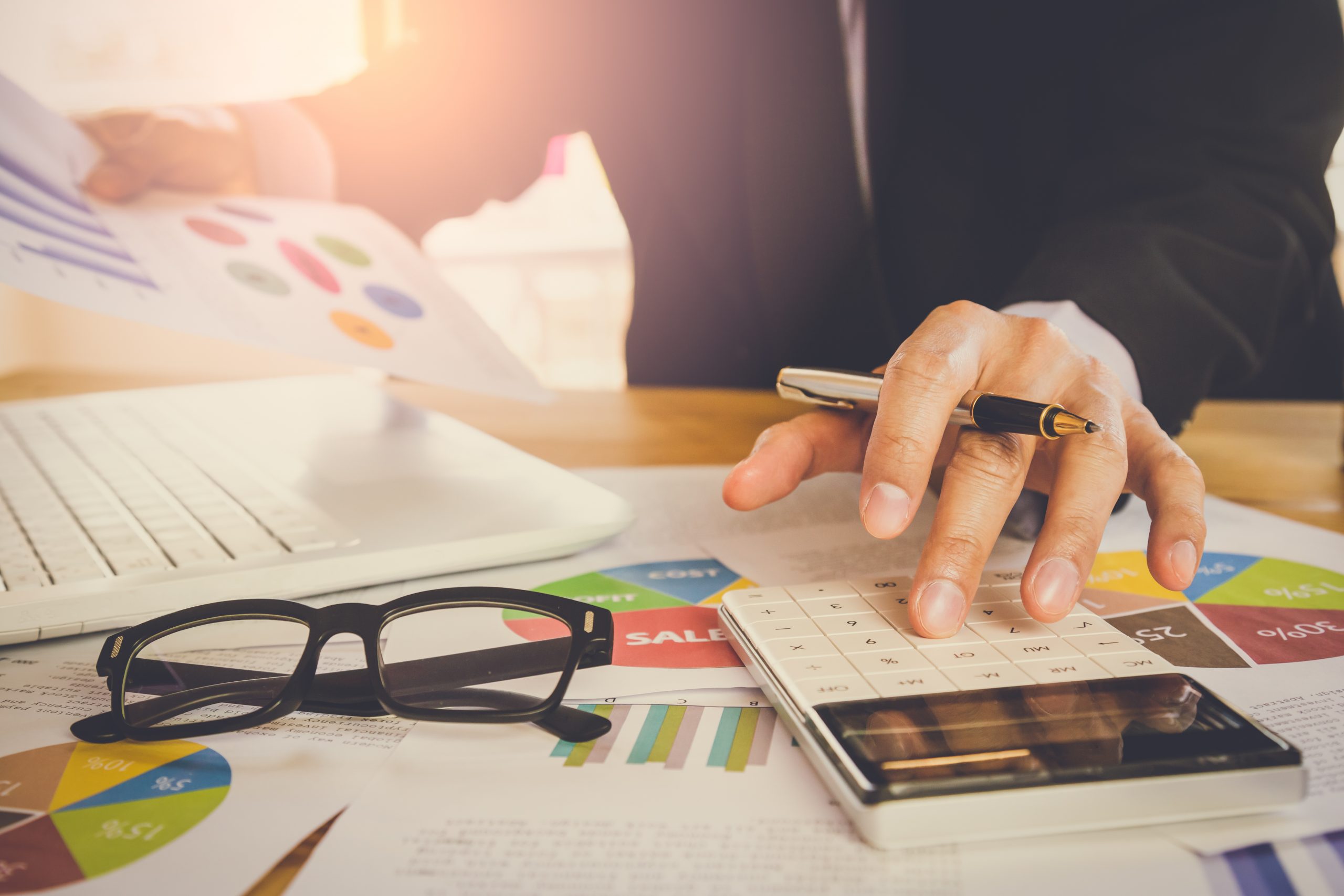 Businessman or accountant working on calculator to calculate business data concept. Accounting,investment advisor consulting situation on the financial report and planning a marketing plan at office.